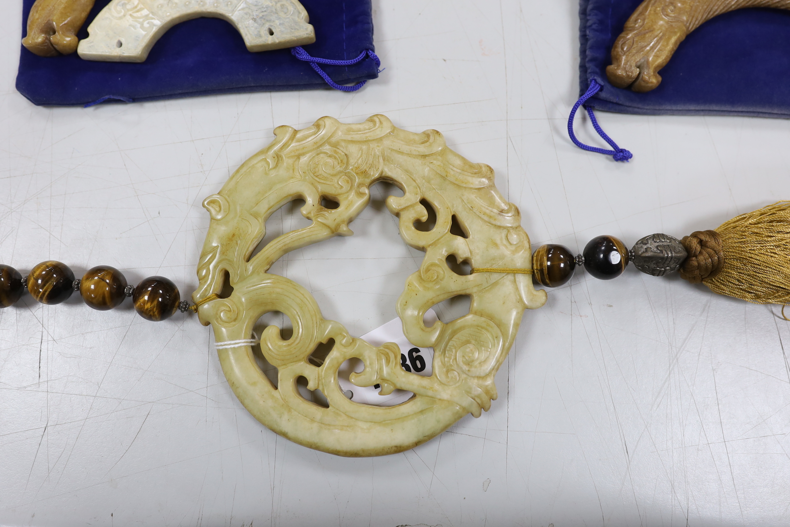 Three Chinese jade carvings, two huang, a large hardstone pendant and disc, largest overall 90cm in length (4)